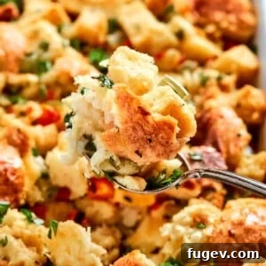 35 Essential Thanksgiving Sides 22 A spoonful of Southern Cornbread Dressing, featuring visible herbs and a moist, golden crumb.