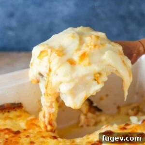 35 Essential Thanksgiving Sides 28 Scalloped Potatoes elegantly presented on a wooden server, highlighting their creamy layers.