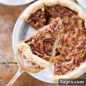 A perfectly sliced pecan pie being served, highlighting its rich filling and inviting texture.