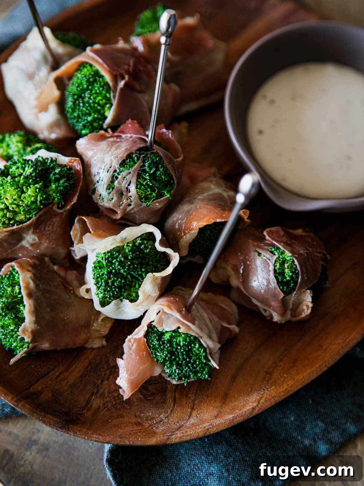 Stress-Free Thanksgiving Recipes 15 Bright green broccoli spears elegantly wrapped in savory prosciutto, creating an appealing appetizer.