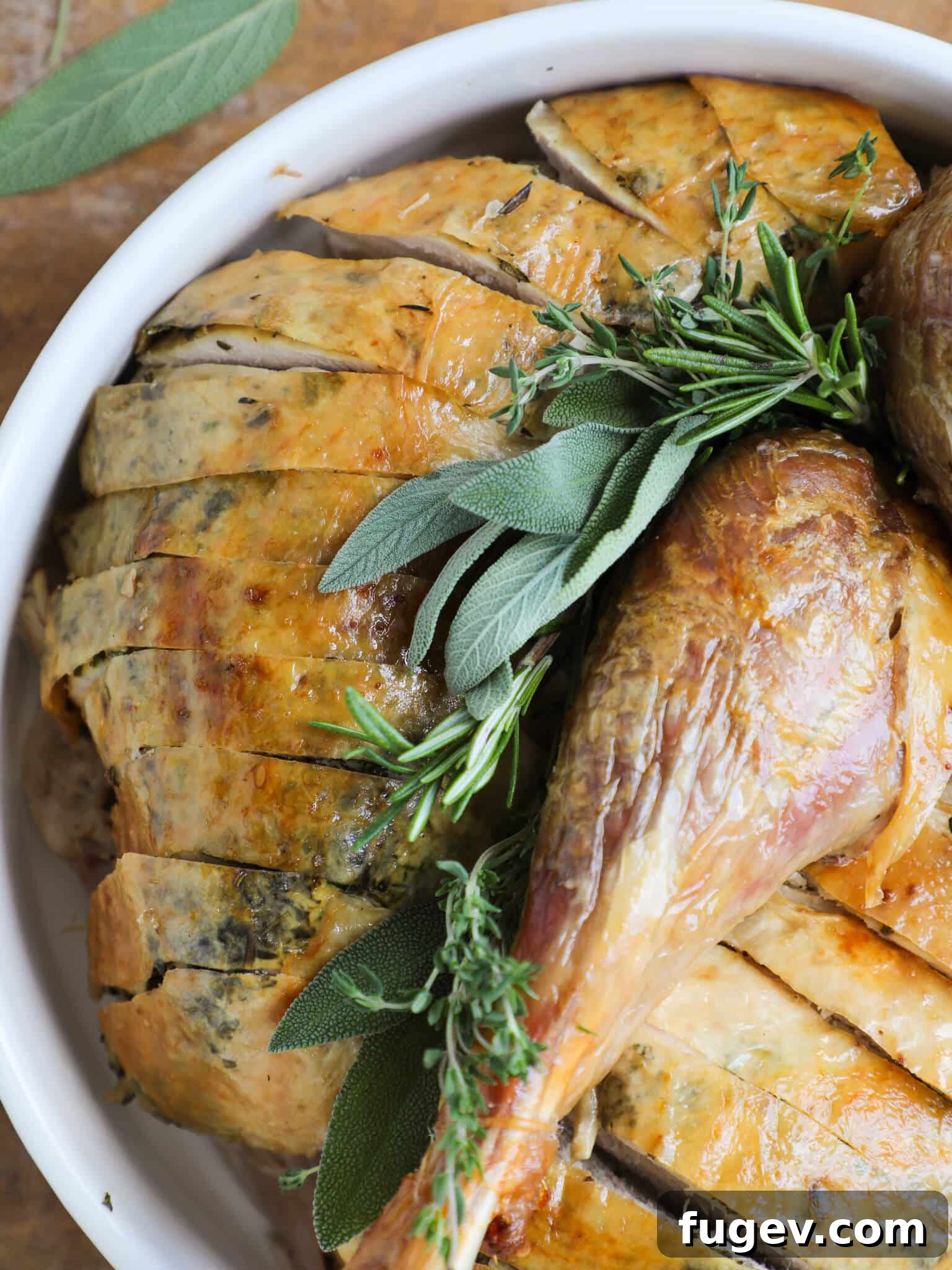 Stress-Free Thanksgiving Recipes 18 A beautifully roasted herb turkey, glistening on a white plate, ready to be carved and served.