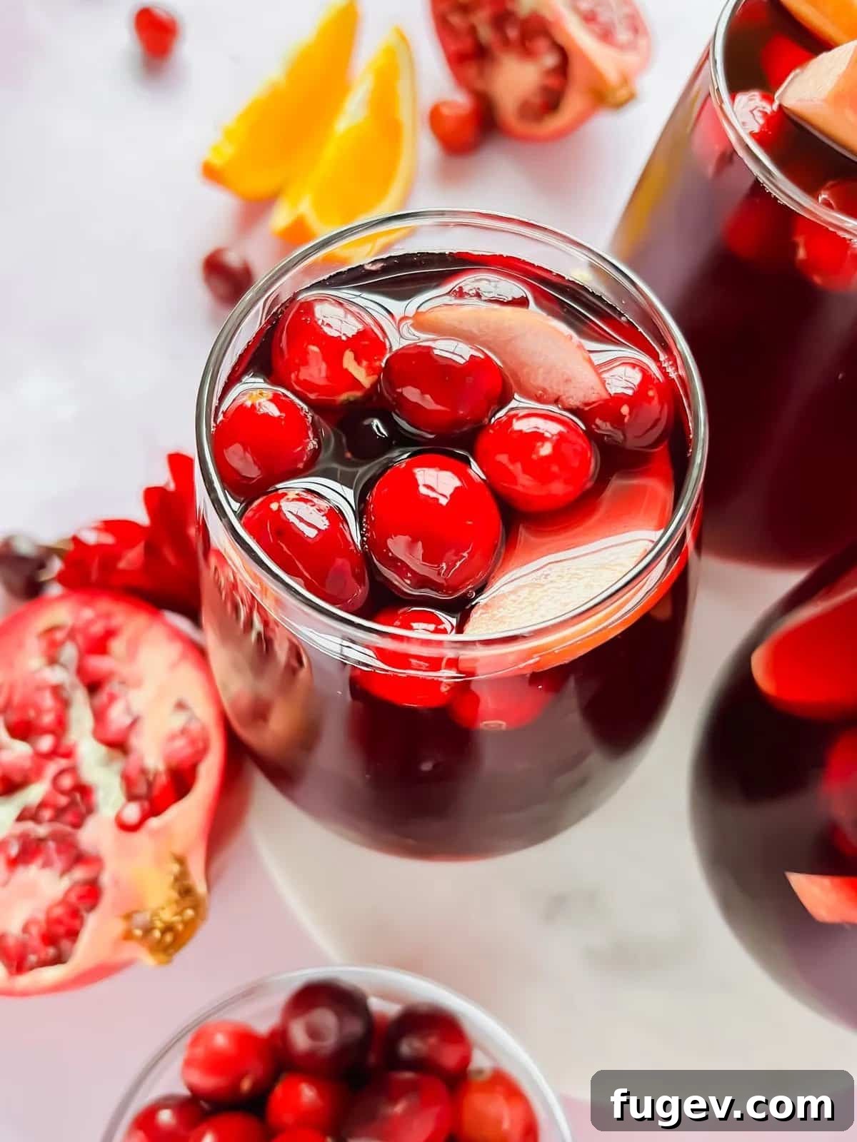 Stress-Free Thanksgiving Recipes 4 A bright red pomegranate cranberry sangria, garnished and ready to be served in a elegant glass.