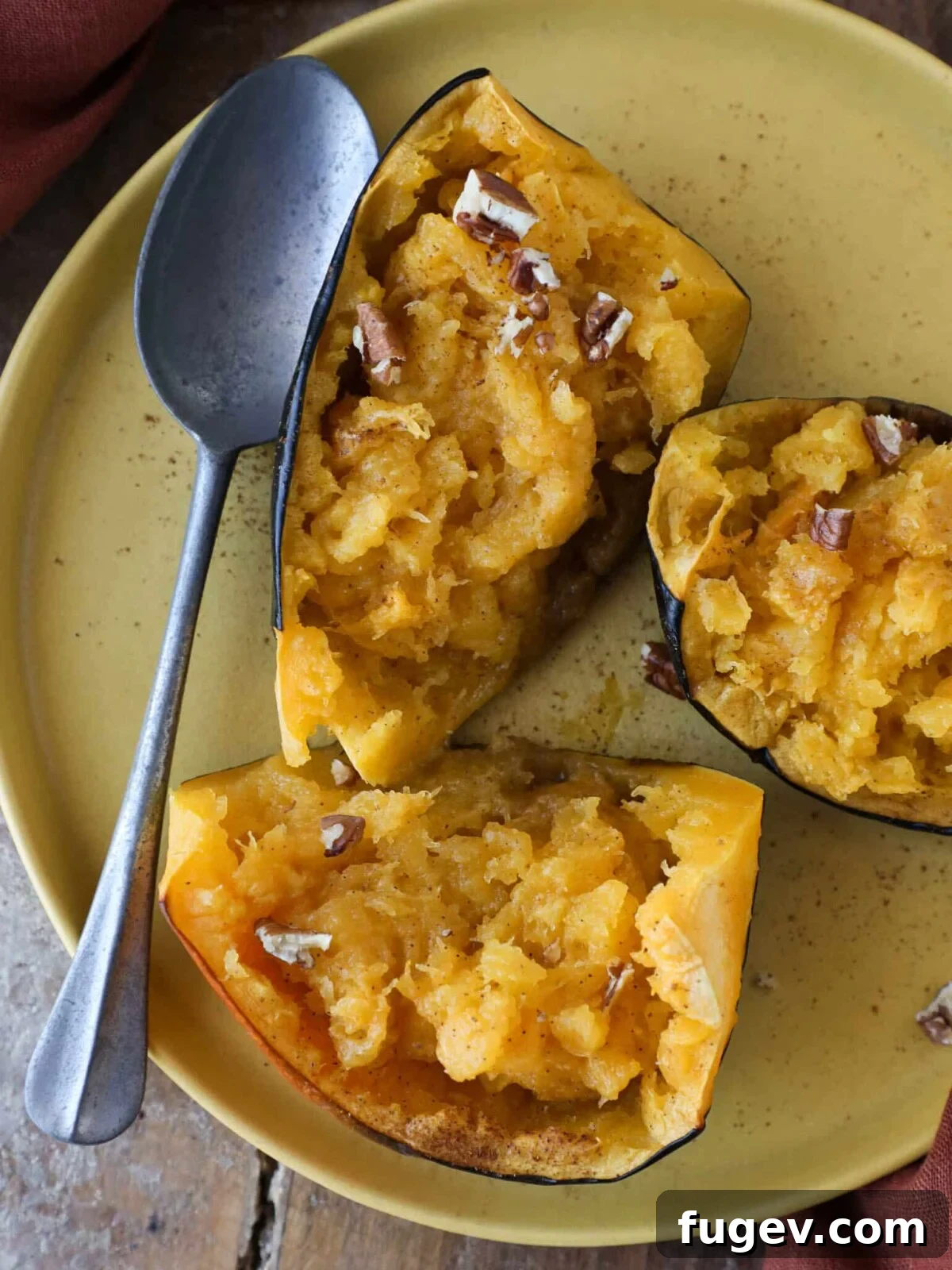 Stress-Free Thanksgiving Recipes 34 A glistening Brown Sugar Baked Acorn Squash, ready to be enjoyed with a silver spoon.