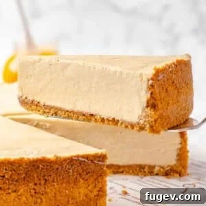 Stress-Free Thanksgiving Recipes 49 A perfectly portioned slice of no-bake pumpkin cheesecake, elegantly presented on a dessert server.