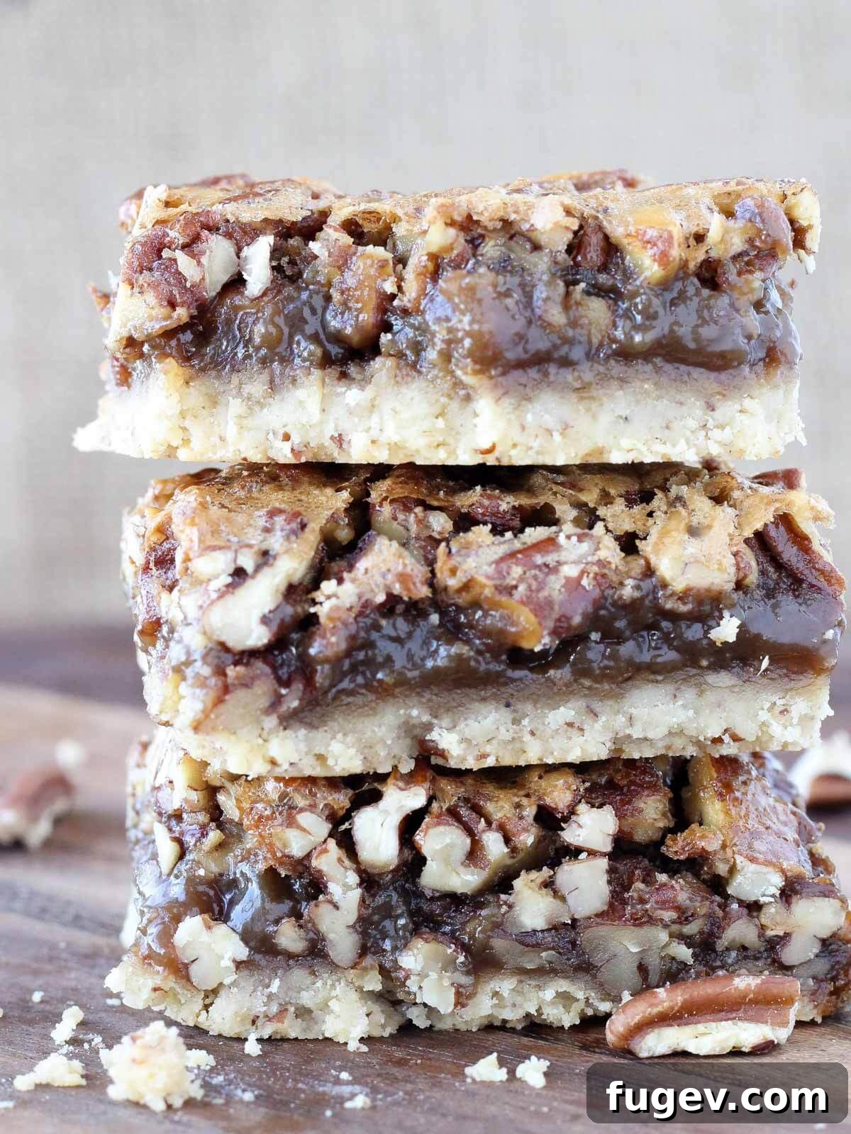 Stress-Free Thanksgiving Recipes 50 Three decadent pecan pie bars, elegantly stacked, showcasing their rich layers.
