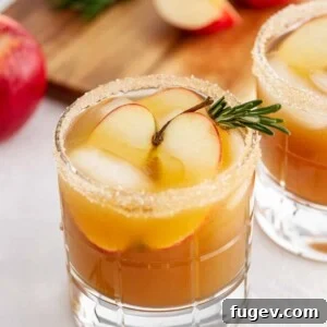 Stress-Free Thanksgiving Recipes 6 A Harvest Apple Ginger Smash cocktail, elegantly garnished with rosemary, evoking cozy fall vibes.