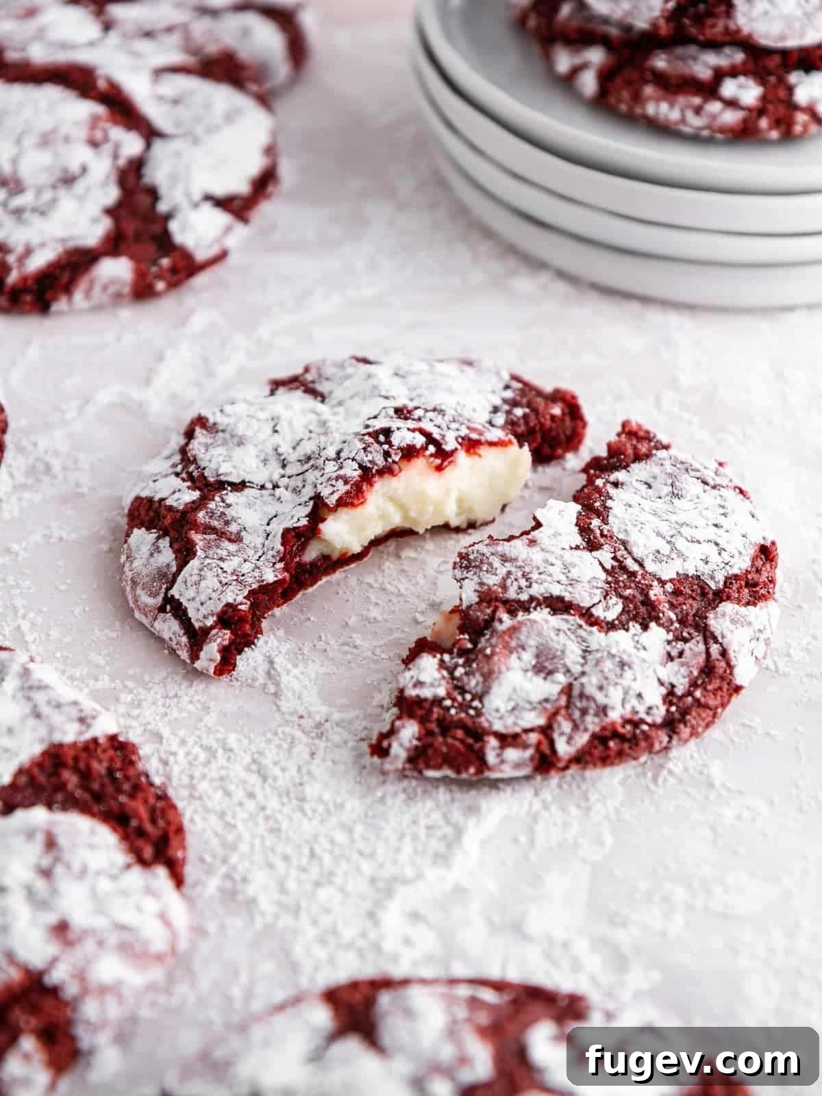 24 Irresistible Christmas Cookies 12 Stuffed red velvet crinkle cookie, broken open to reveal its creamy cheesecake filling.