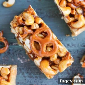 Cashew Caramel Pretzel Blondies on a teal wooden surface, showing their enticing layers.