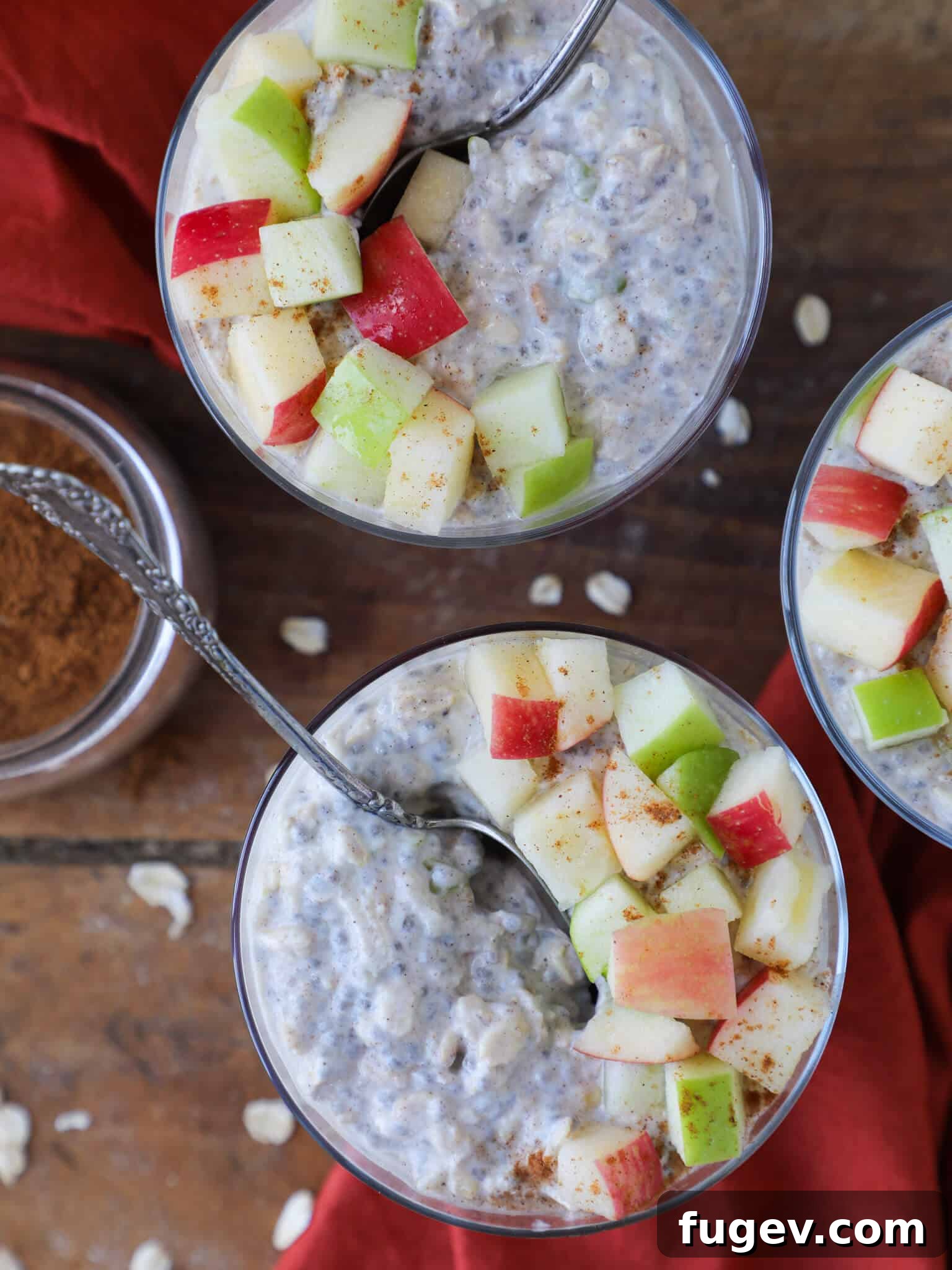 Cozy Apple Pie Overnight Oats 2 Delicious Apple Pie Overnight Oats garnished with fresh apple slices and a spoon, highlighting the wholesome ingredients and inviting texture.
