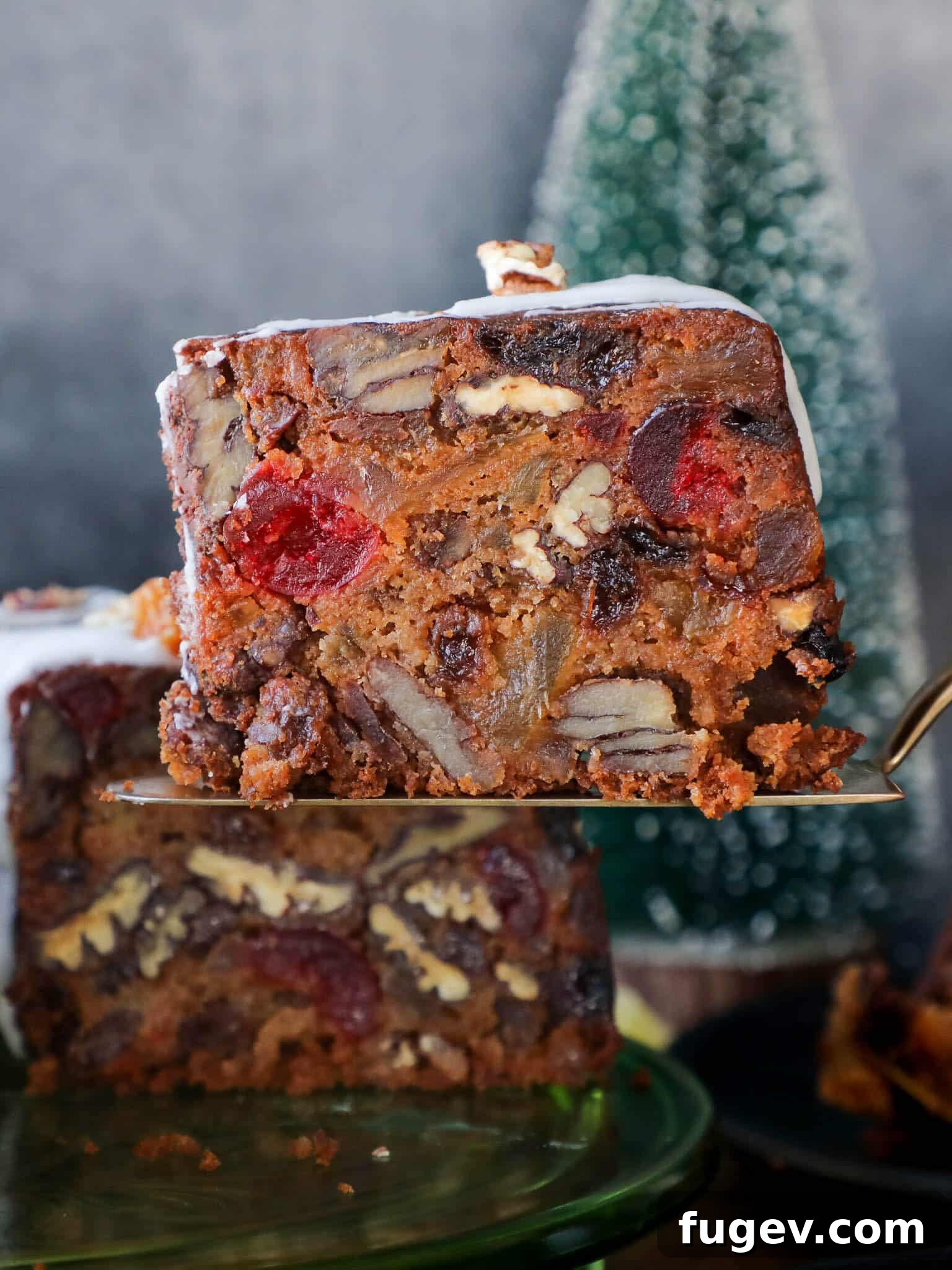 Candied Fruit Confection 2 A slice of moist fruit cake served on a cake server, showcasing its rich texture and fruit content.