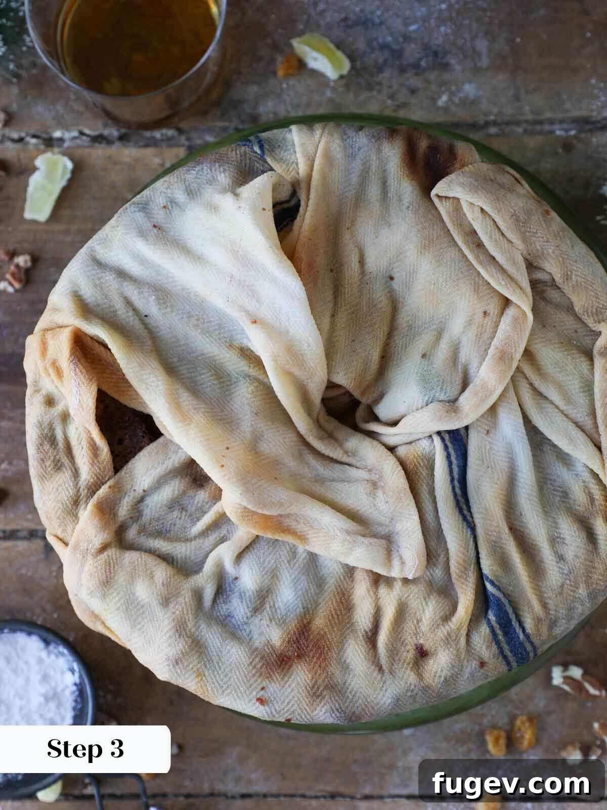 Candied Fruit Confection 9 Fruit cake wrapped in a towel, preparing for the soaking process.