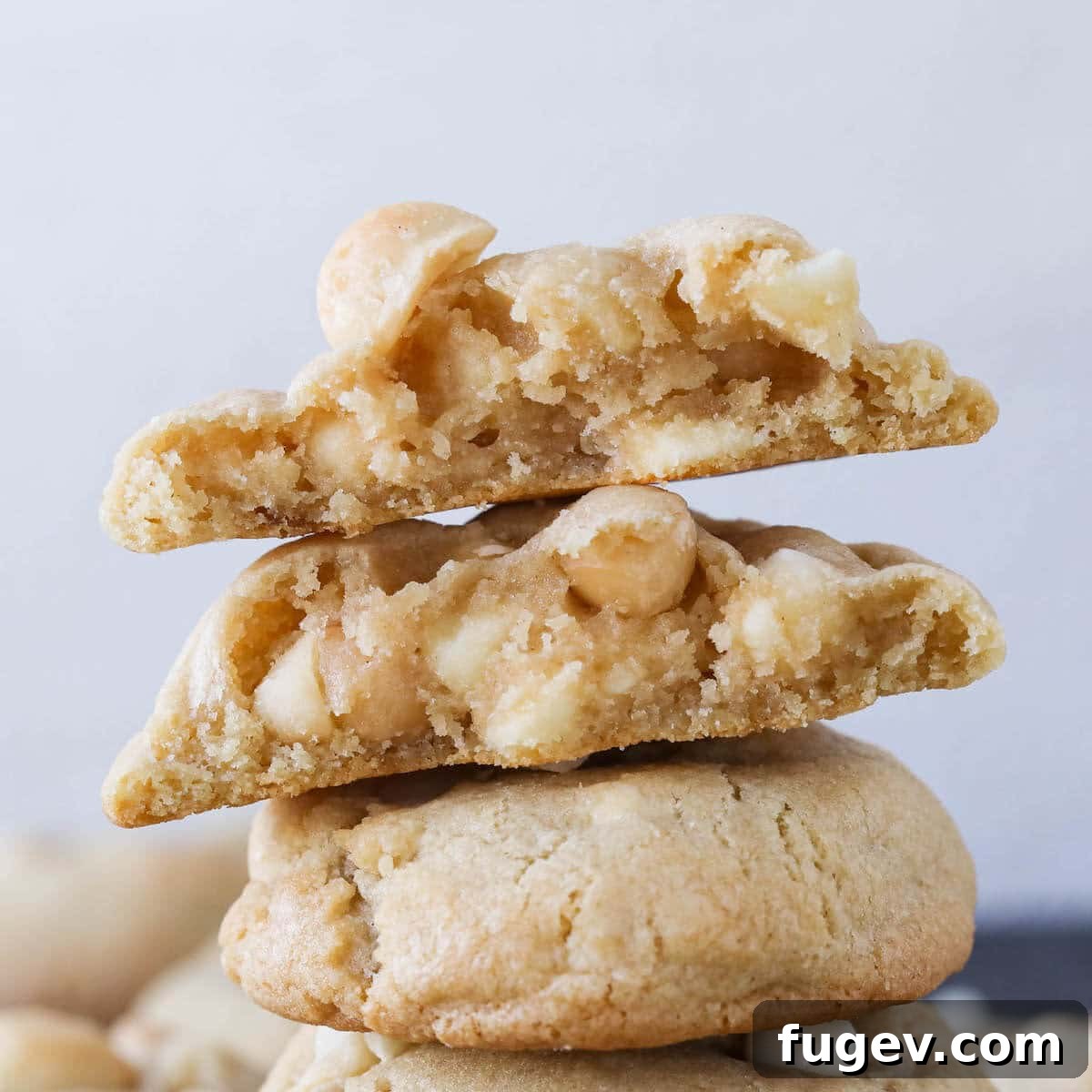 Creamy White Chocolate Macadamia Nut Delights 4 Three white chocolate macadamia nut cookies stacked neatly.