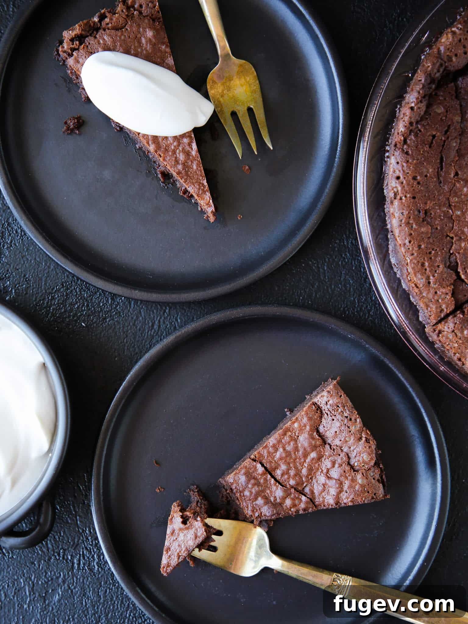 Sweets for Your Sweetheart 2 Flourless Chocolate Decadence Cake slices on black plates with whipped cream, ideal for elegant Valentine's Day Desserts.