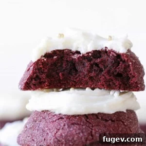 The inside of a red velvet cookie stacked on top of another red velvet cookie, revealing its moist crumb.