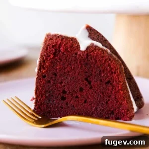 Red Velvet Pound Cake with Cream Cheese Glaze slice from the side, showing its rich texture.