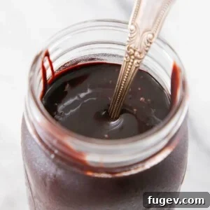 Chocolate fudge sauce in a jar on marble, a versatile and delicious topping.