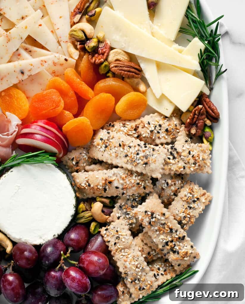 The Ultimate Homemade Everything Crackers 7 A vibrant grazing board featuring homemade everything bagel crackers, cheeses, fruits, and dips