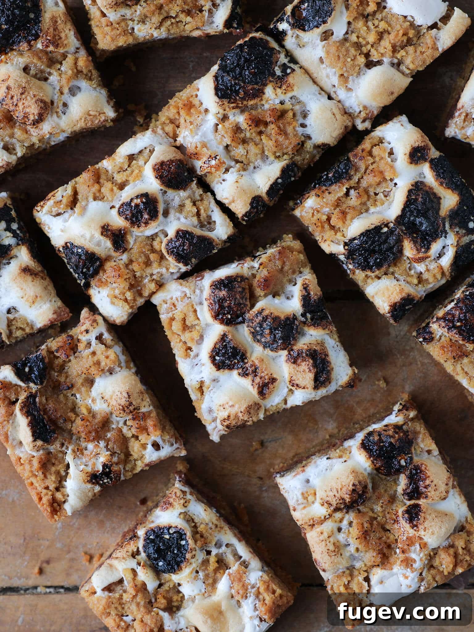 Ooey Gooey S'mores Crumble Bars 3 Soft Chewy S'mores Crumble Bars artfully arranged on a rustic wooden surface