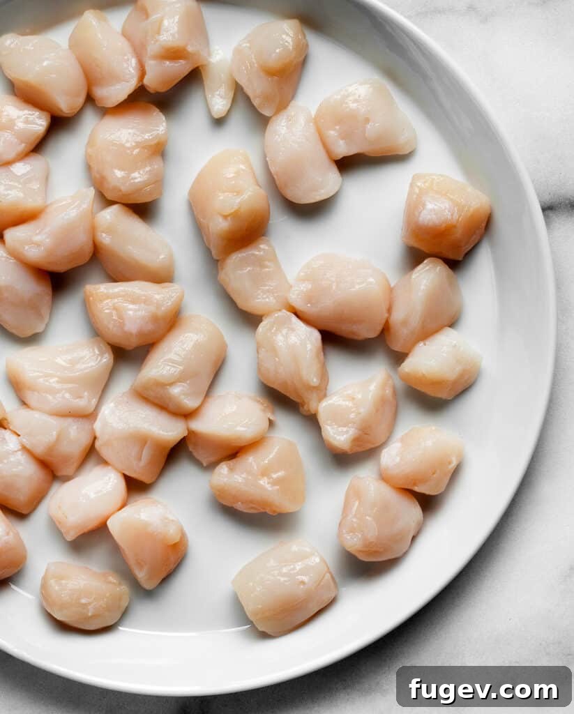 Lemon-Kissed Bay Scallops with Shallots 3 Raw scallops on a plate