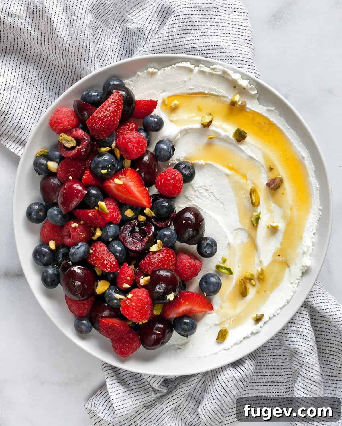 Homemade Labneh: The Greek Yogurt Secret 7 A beautifully arranged serving of labneh adorned with a colorful assortment of fresh fruit, a generous drizzle of golden honey, and a sprinkle of crunchy nuts, showcasing its appeal as a sweet treat.