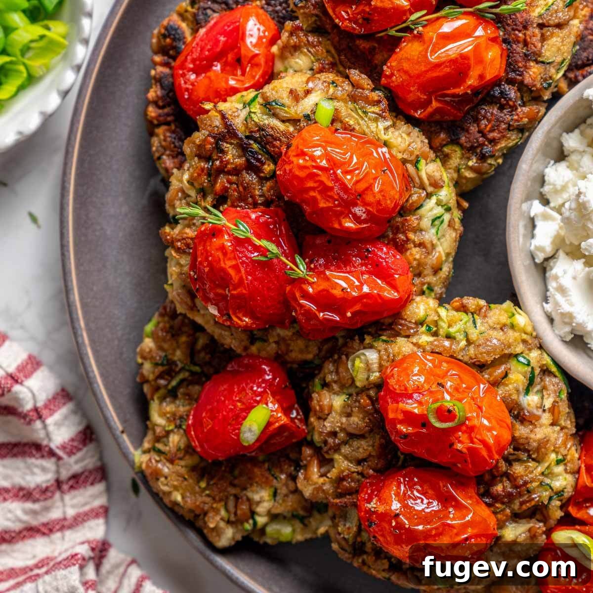 Golden Zucchini Fritters Delight 4 zucchini fritters ready to serve with tomatoes.