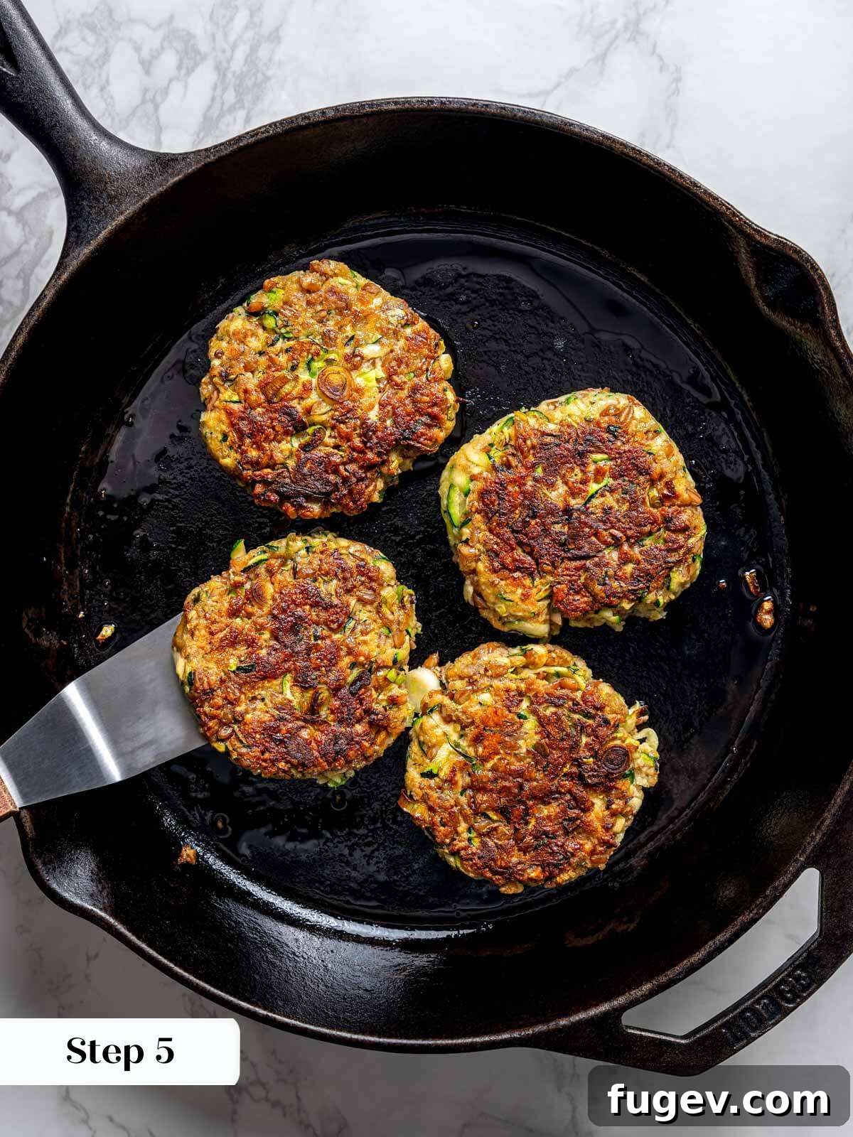 Golden Zucchini Fritters Delight 10 4 zucchini fritter patties cooked to golden brown in cast iron pan.