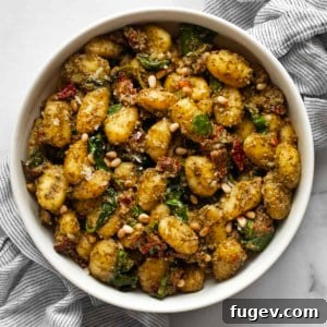 Gnocchi with pesto, sun-dried tomatoes and spinach in a bowl, ready to be served.