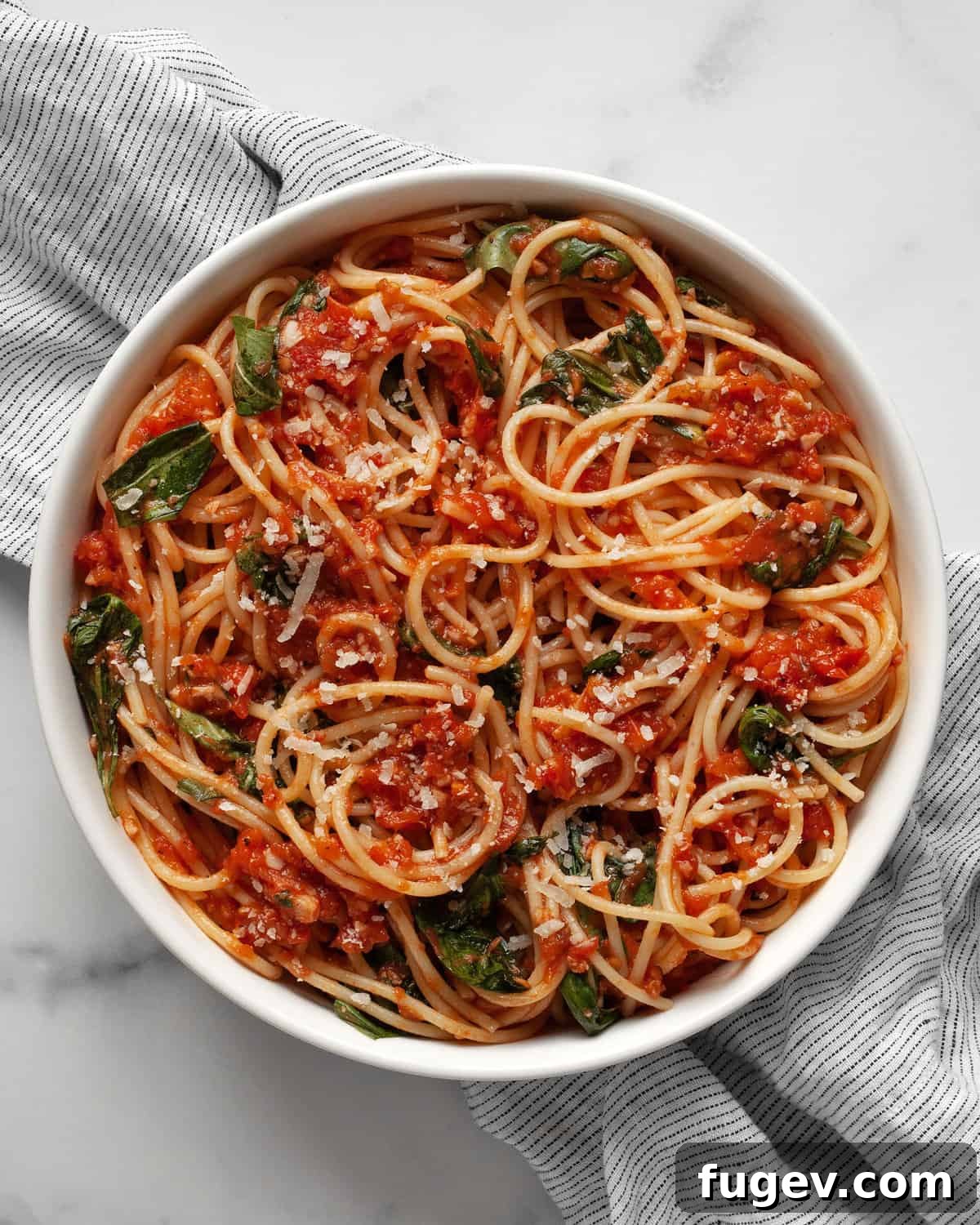Garden Fresh Tomato Basil Delight 2 A beautifully plated bowl of fresh tomato basil pasta, garnished with fresh basil leaves and grated Parmesan cheese, ready to be enjoyed.