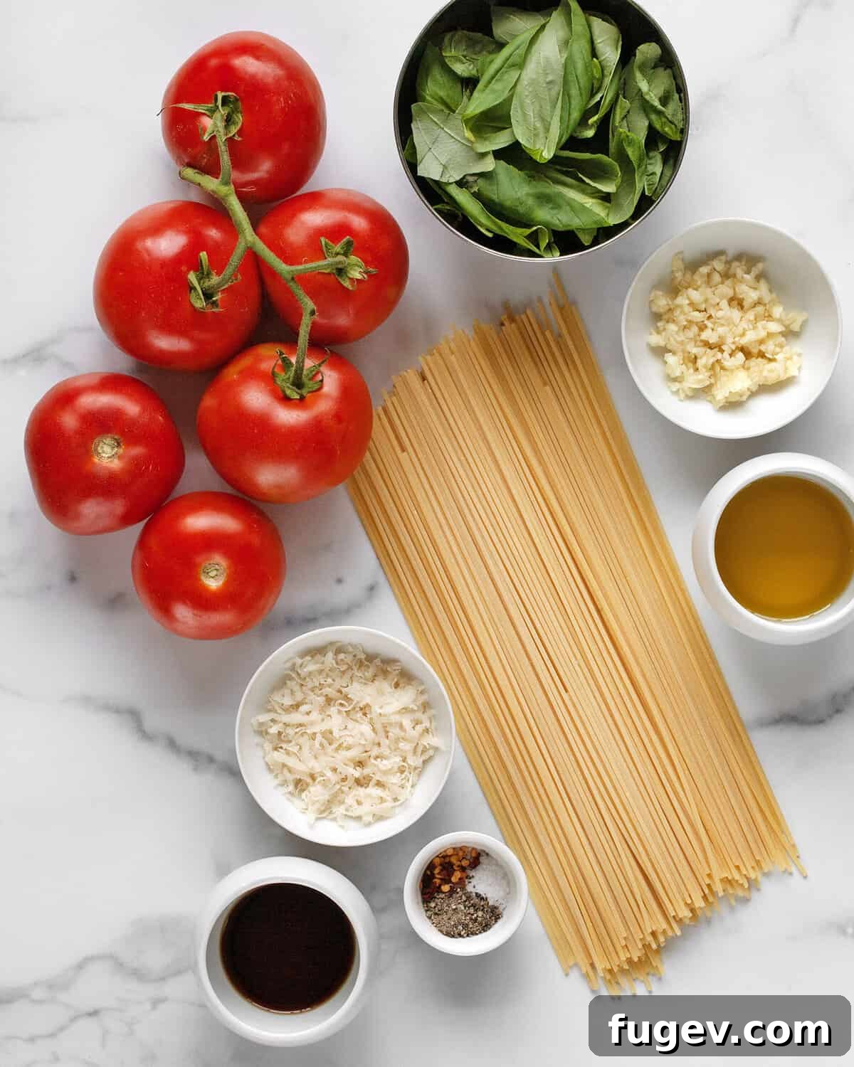 Garden Fresh Tomato Basil Delight 3 A flat lay photograph showcasing all the fresh ingredients needed for tomato basil pasta, including ripe tomatoes, fresh basil, spaghetti, garlic cloves, Parmesan cheese, balsamic vinegar, olive oil, and seasonings.