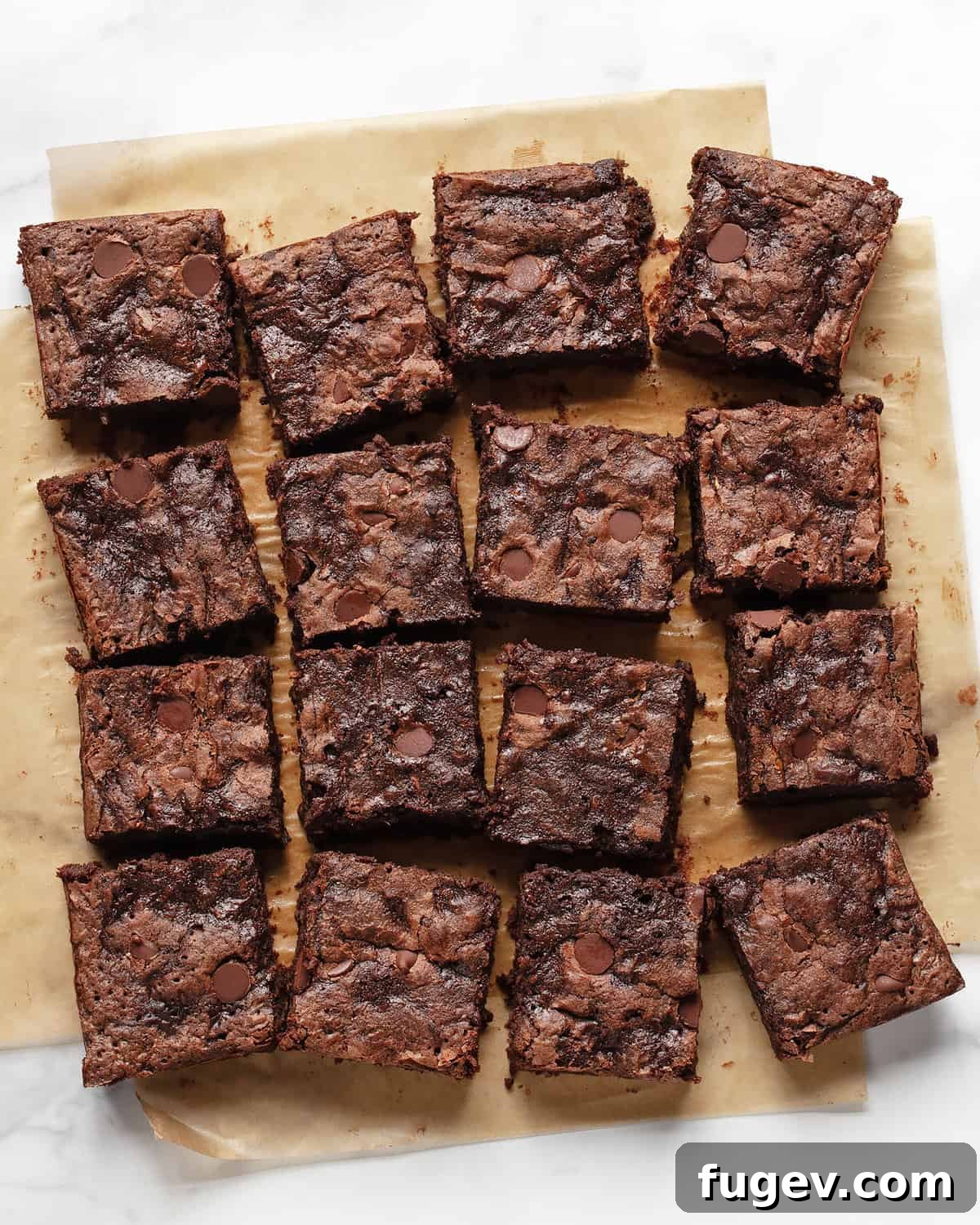 Sneaky Zucchini Brownie Bliss 2 Freshly baked zucchini brownies, perfectly cut into neat rows on parchment paper, showcasing their fudgy texture.