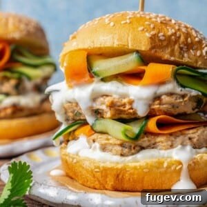 Succulent Chicken Burgers 11 Chicken burgers topped with white sauce and pickled veggies, presented beautifully.