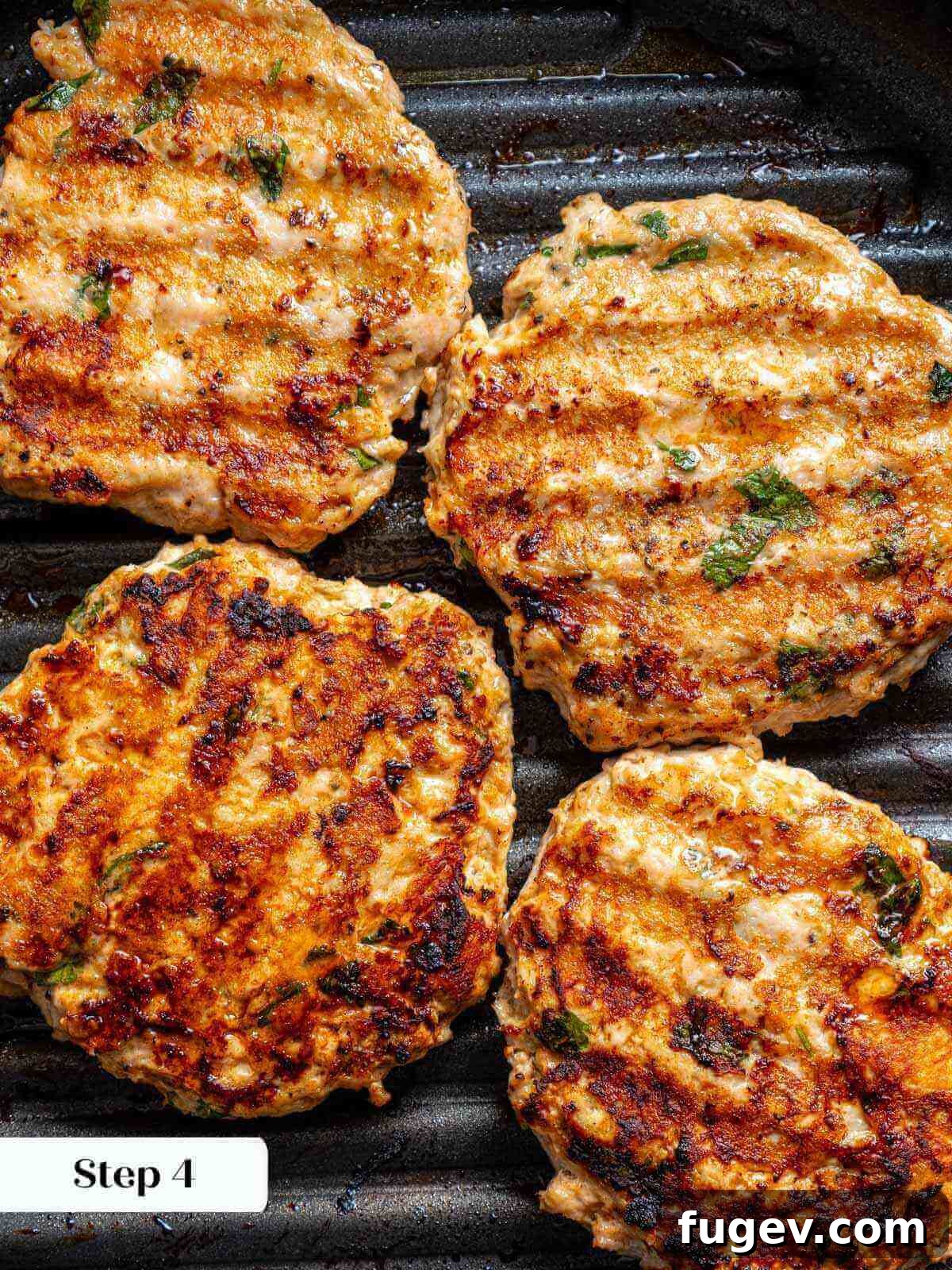 Succulent Chicken Burgers 7 Chicken burgers sizzling on a hot grill pan, developing beautiful sear marks.