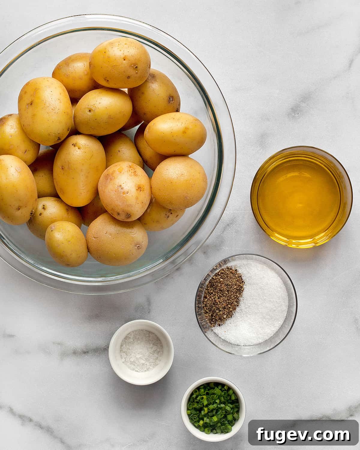 Crispy Smashed Potatoes 4 A collection of ingredients for smashed potatoes: small yellow potatoes, olive oil, kosher salt, black pepper, and fresh chives.
