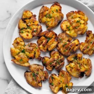 Roasted smashed potatoes on a plate, ready to be served.