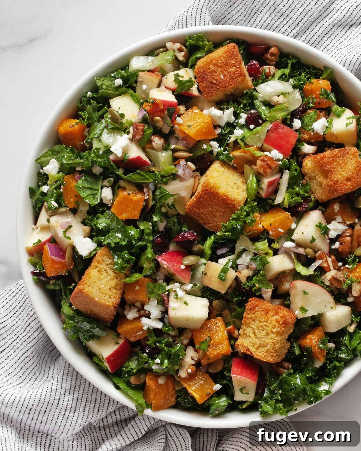 Golden Autumn Harvest Salad 2 Salad with roasted butternut squash, apples, kale and romaine in a bowl.