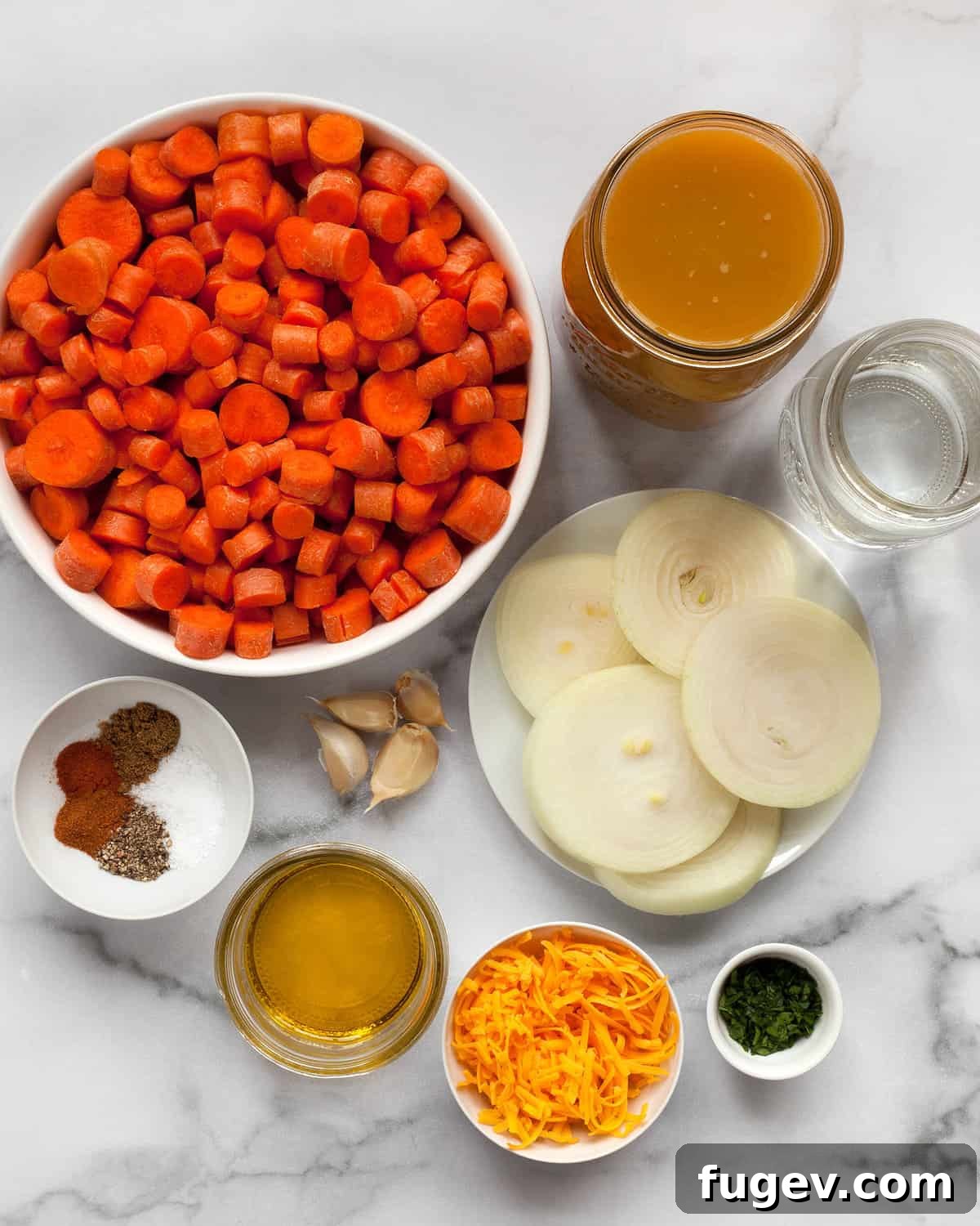 Velvety Roasted Carrot Bisque 3 A flat lay photograph showcasing all the fresh, vibrant ingredients needed for roasted carrot soup: bright orange carrots, neatly sliced onions, whole garlic cloves, various dried spices in small bowls, vegetable broth in a carton, a block of cheddar cheese, and a bunch of fresh parsley.