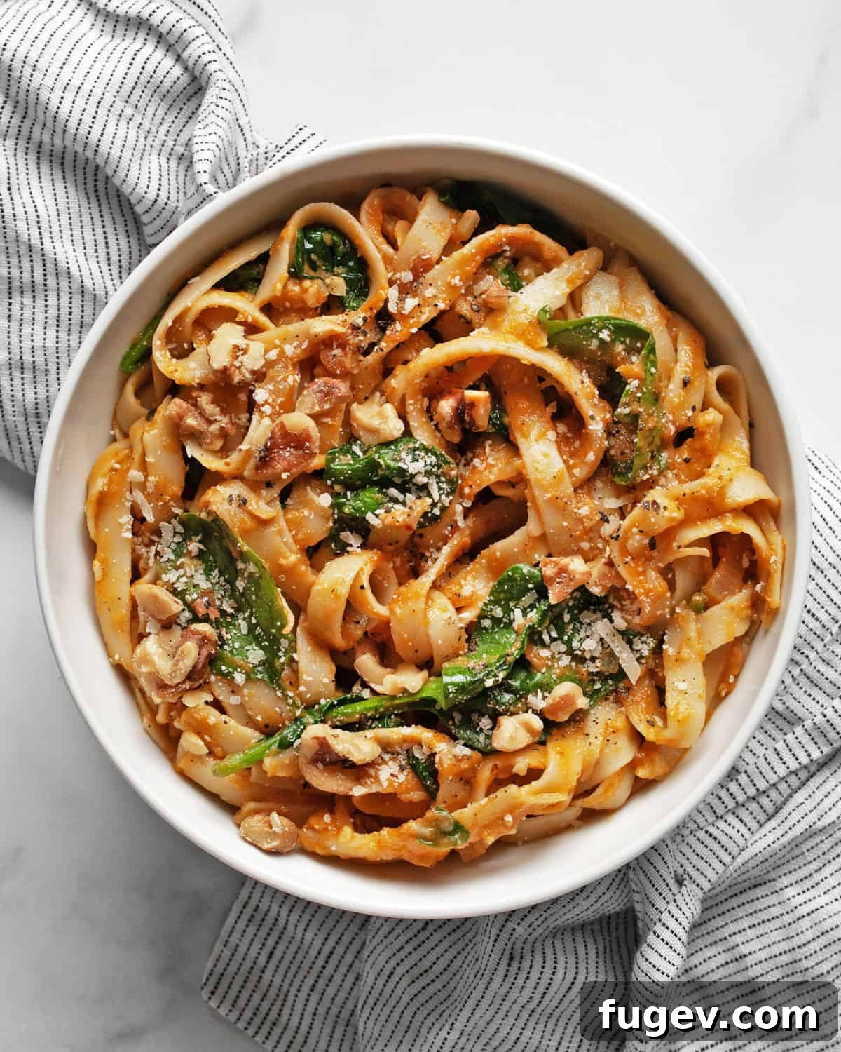 Creamy Pumpkin Spinach Pasta 7 Close-up of a bowl of creamy pumpkin pasta with spinach, ready to eat.