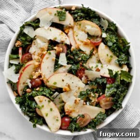 20 Fresh & Festive Thanksgiving Salad Recipes 8 Apple salad with kale, grapes and walnuts in a bowl.
