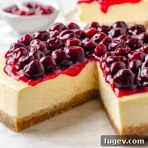 Homemade cherry topping dripping down a creamy cheesecake with golden crust