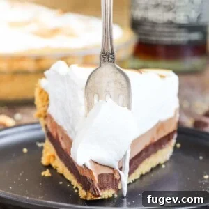 No-bake whiskey s'mores pie with an antique fork, showcasing its rich layers