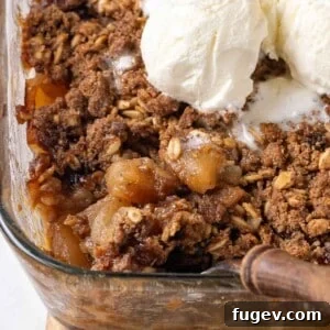 Baked apple crisp being dished from a baking pan