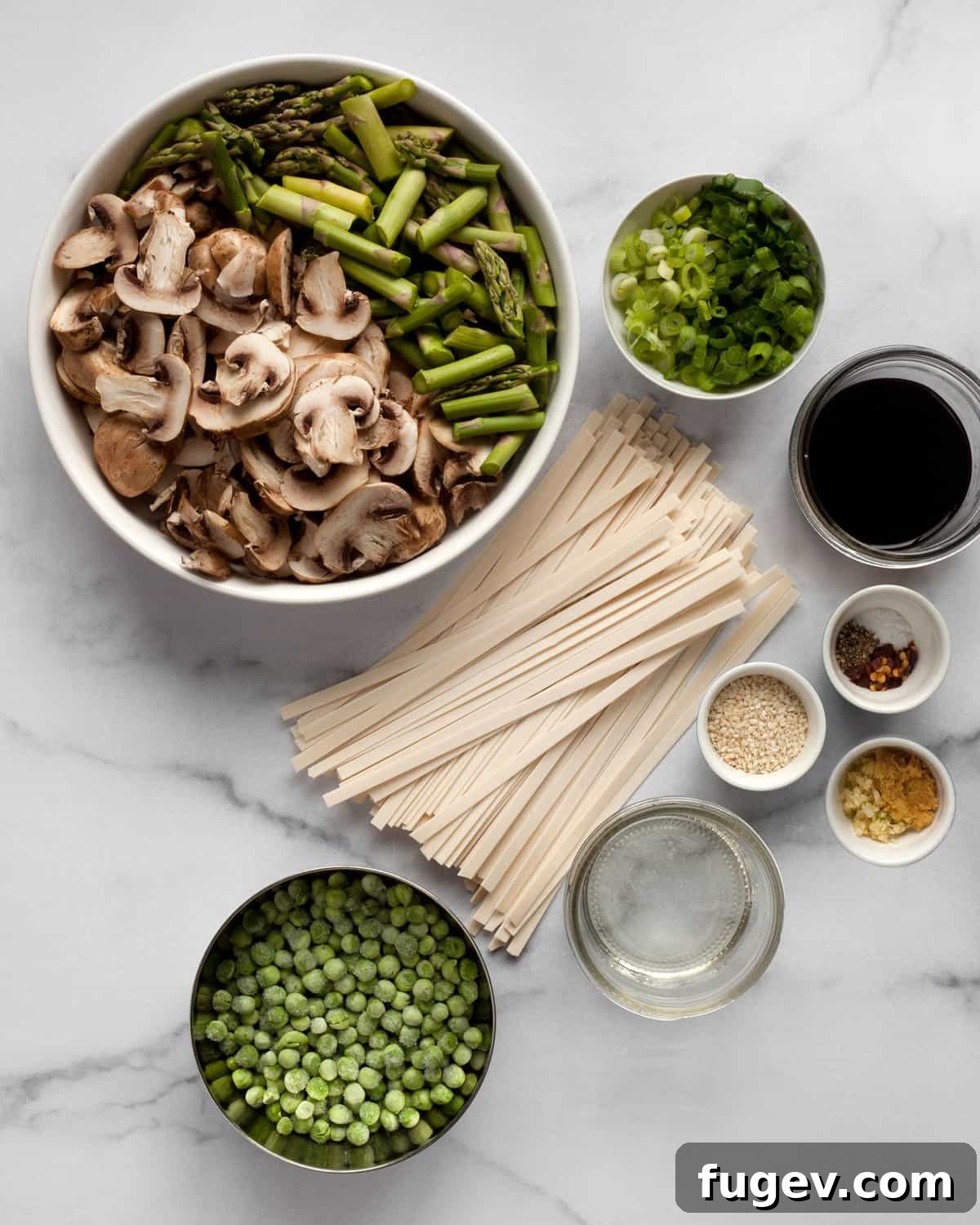 Vibrant Asparagus, Mushroom and Pea Stir-Fry 3 Essential ingredients for udon noodle stir-fry laid out: asparagus, mushrooms, peas, scallions, garlic, ginger, soy sauce, and udon noodles.