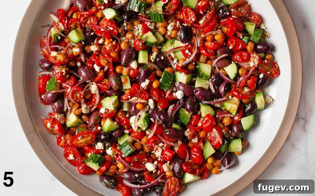Mediterranean Chickpea Salad 6 Greek chickpea salad tossed with red wine vinaigrette in a large bowl, ready to be served.