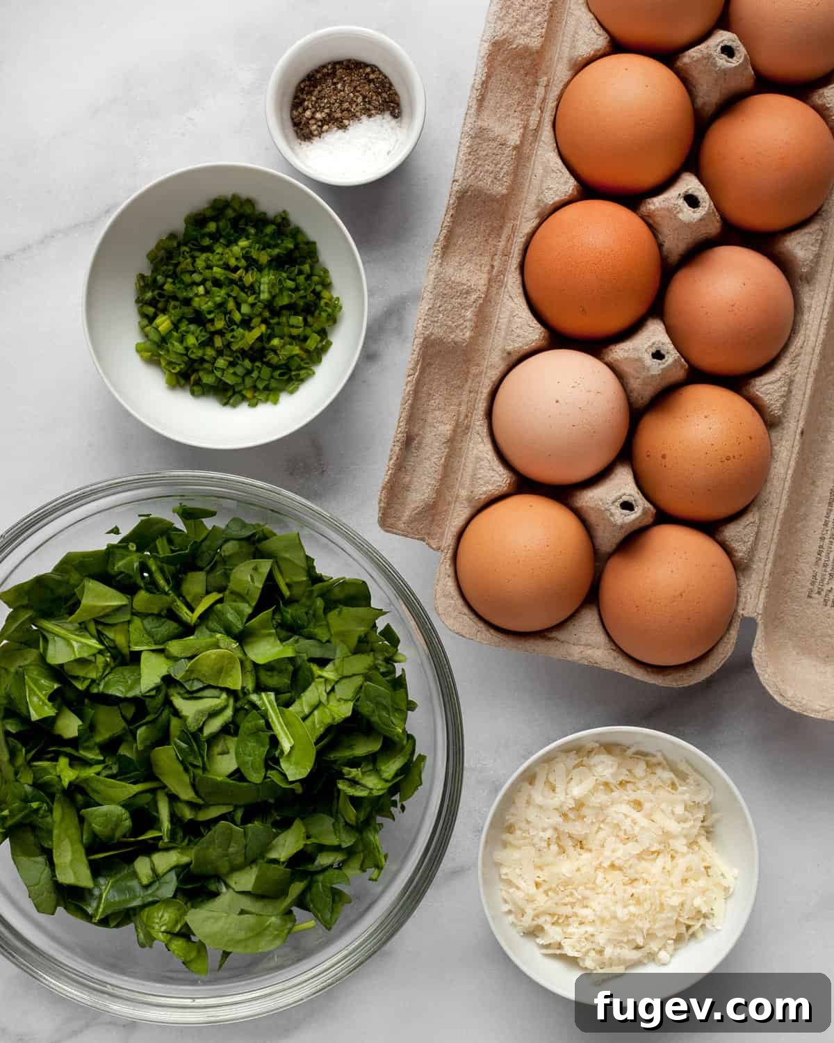 Savory Spinach & Parmesan Frittata Bites 3 All the ingredients for mini frittatas laid out: eggs, fresh spinach, grated Parmesan cheese, chopped chives, salt, and pepper.