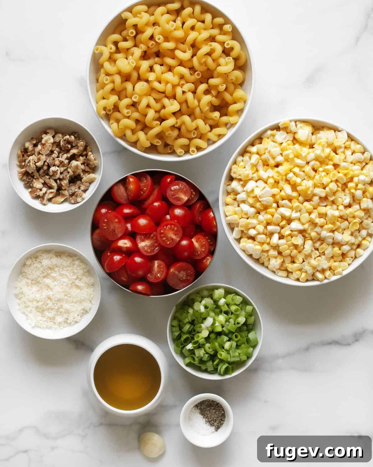 Golden Corn Pesto Pasta 3 A vibrant flat lay image showcasing all the fresh ingredients needed for sweet corn pesto pasta: corn on the cob, cherry tomatoes, walnuts, scallions, olive oil, parmesan cheese, cavatappi pasta, and salt and pepper.