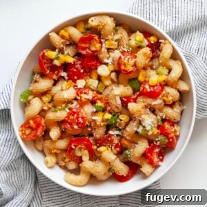 Pasta with corn pesto and roasted tomatoes in a bowl.