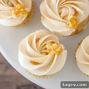 Caramel Apple Cupcakes elegantly arranged on a pristine marble cake stand, showcasing their golden caramel frosting and inviting appeal.