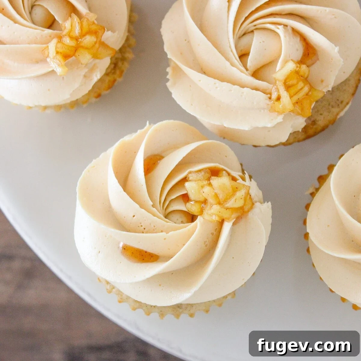 Caramel Apple Orchard Delights 4 A collection of beautifully decorated Caramel Apple Cupcakes displayed on a stylish marble cake stand, ready to be enjoyed.