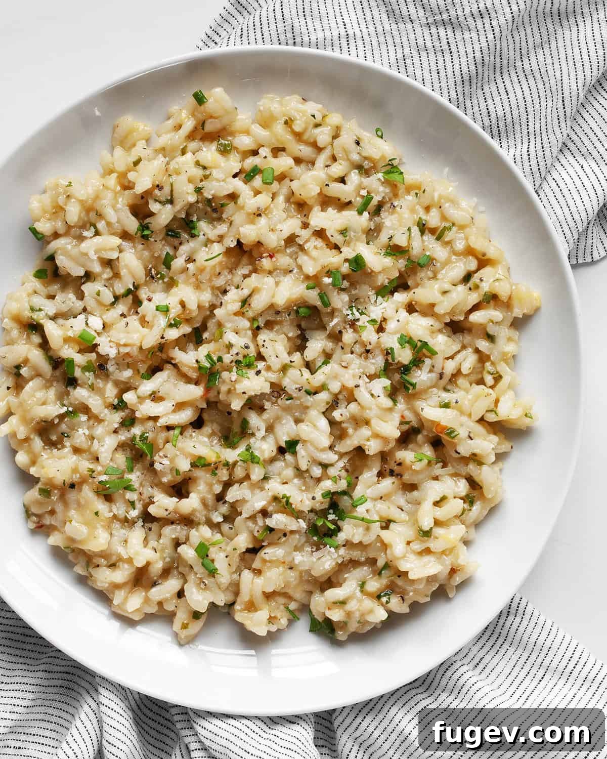 Golden Baked Lemon Risotto 2 Creamy baked lemon risotto garnished with fresh herbs on a plate, ready to be served.
