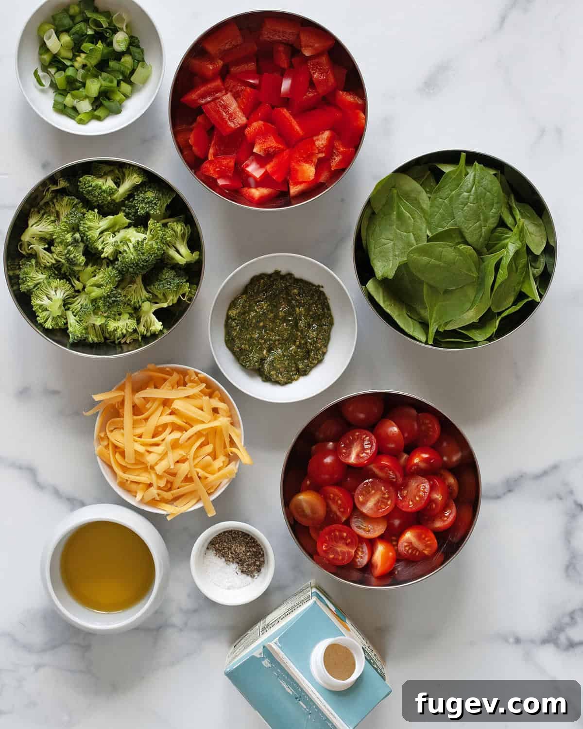 Vibrant Roasted Vegetable Egg White Frittata 3 Fresh ingredients laid out on a kitchen counter: liquid egg whites, ripe cherry tomatoes, vibrant red bell peppers, fresh broccoli florets, shredded cheddar cheese, baby spinach, a jar of pesto, olive oil, and sliced scallions, alongside salt and pepper.
